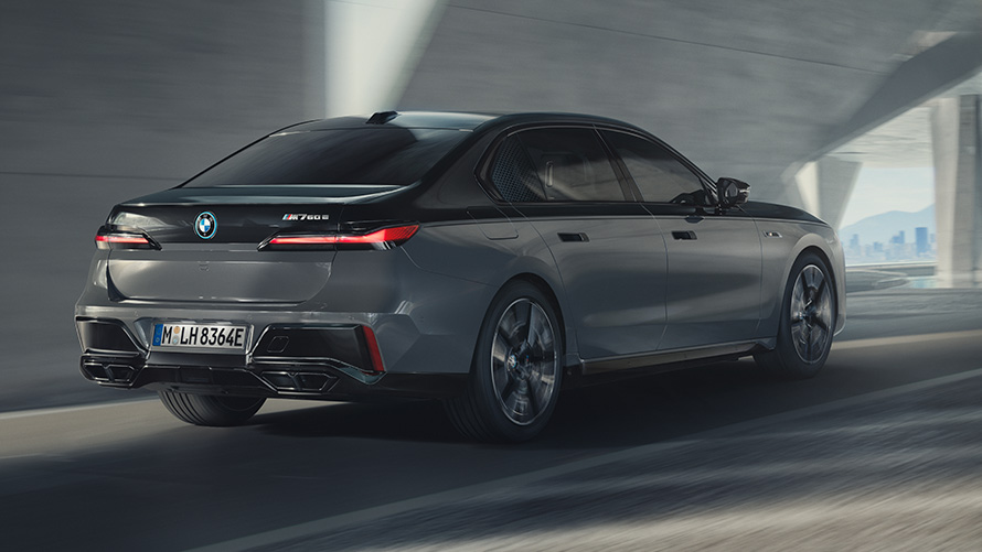 BMW M760e xDrive Limousine G70 M Performance Paket BMW M760e xDrive Limousine G70 M Performance Paket BMW BMW Individual Two-Tone Lackierung Saphirschwarz metallic BMW Individual Dravitgrau metallic Dreiviertel Heckansicht fahrend auf der Straße