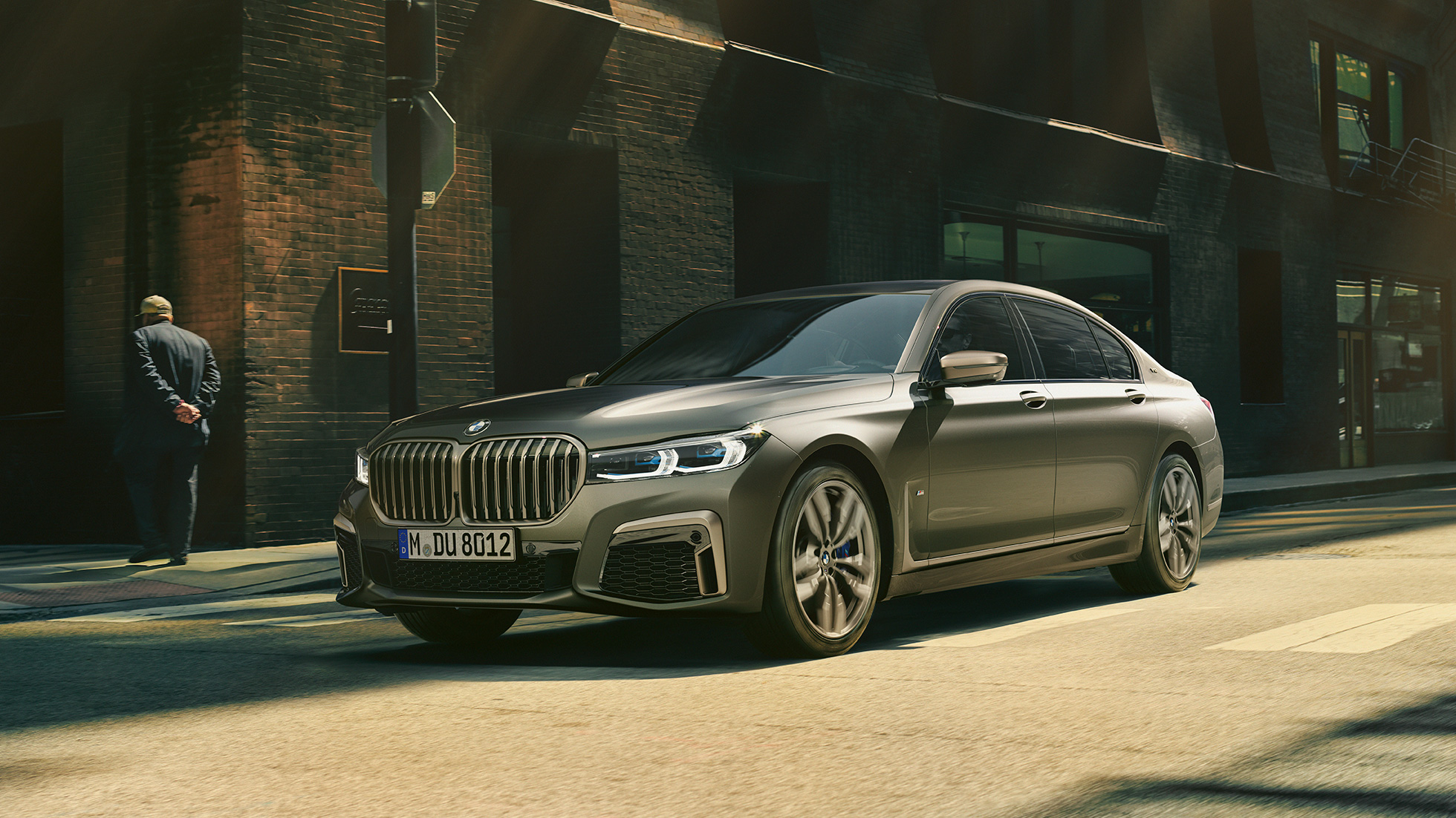BMW M760Li xDrive Berline dans un décor urbain G11 BMW M760Li xDrive Berline, se déplaçant sur une route dans un décor urbain, vue de profil de la partie avant du véhicule. G11