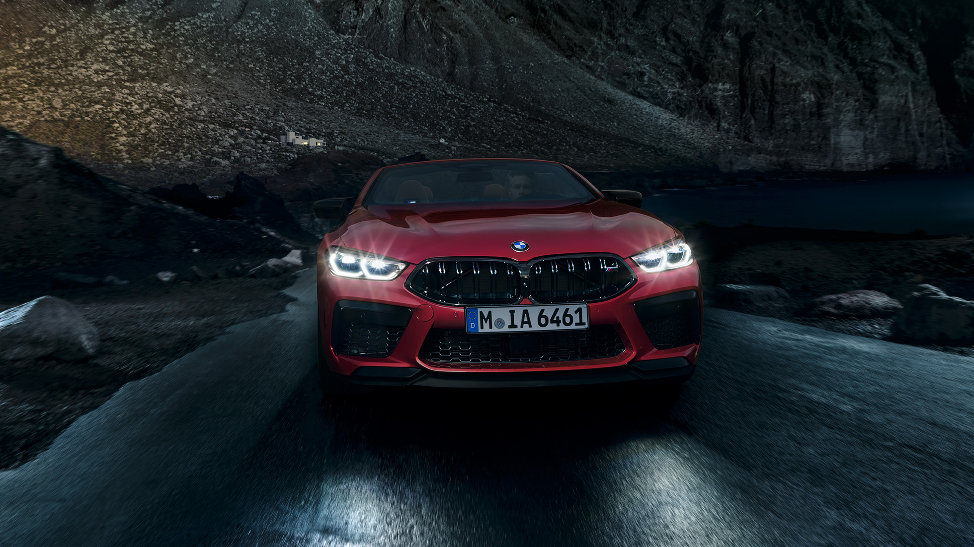 BMW M8 Competition Cabrio, vue avant F91. BMW M8 Competition Cabrio en Motegi Rot metallic avec phares allumés, vue avant, en conduite de nuit F91.