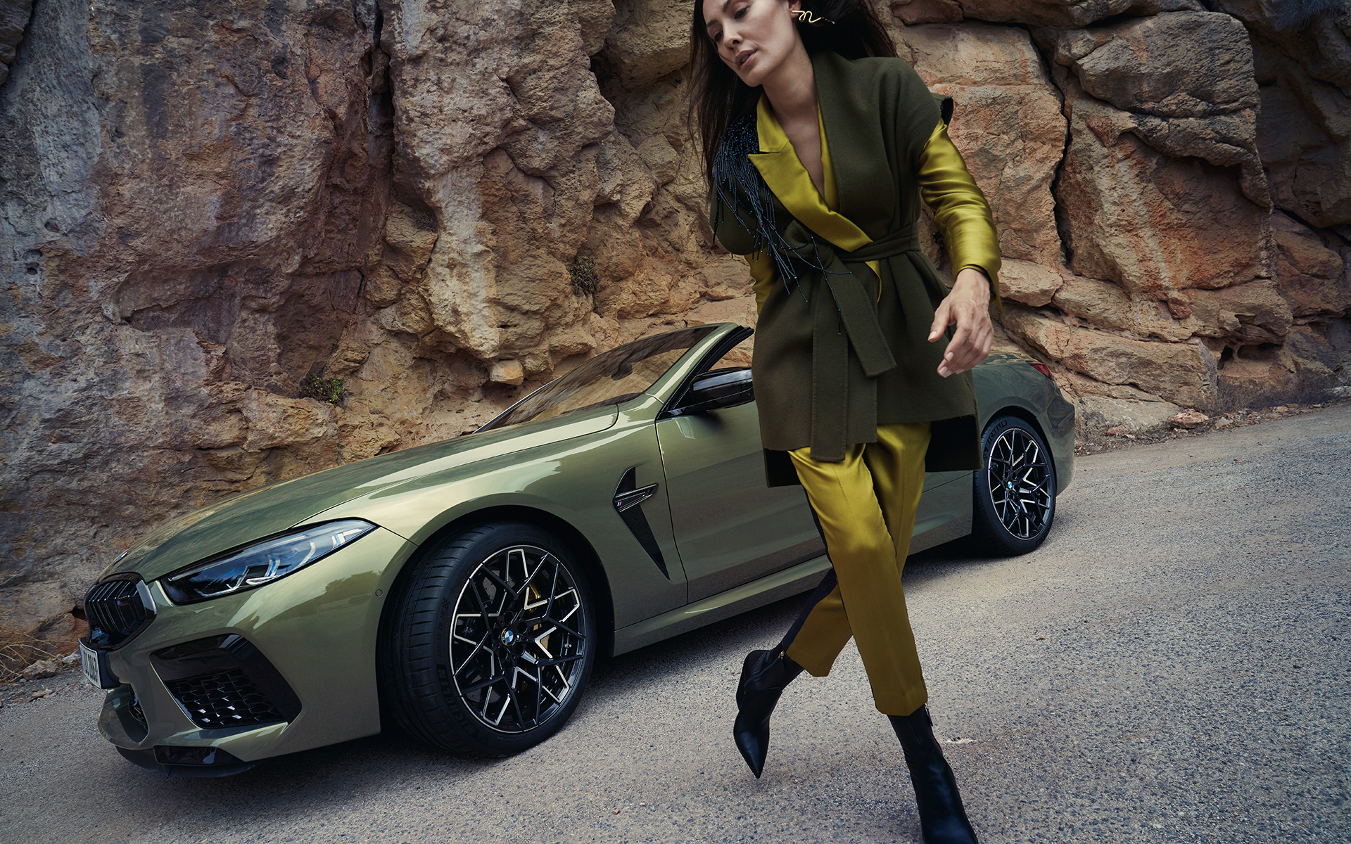 BMW M8 Competition Cabrio F91 LCI Facelift 2022 BMW Individual Brass metallic Dreiviertel-Frontansicht stehend in steinigem Gelände mit weiblichem Model