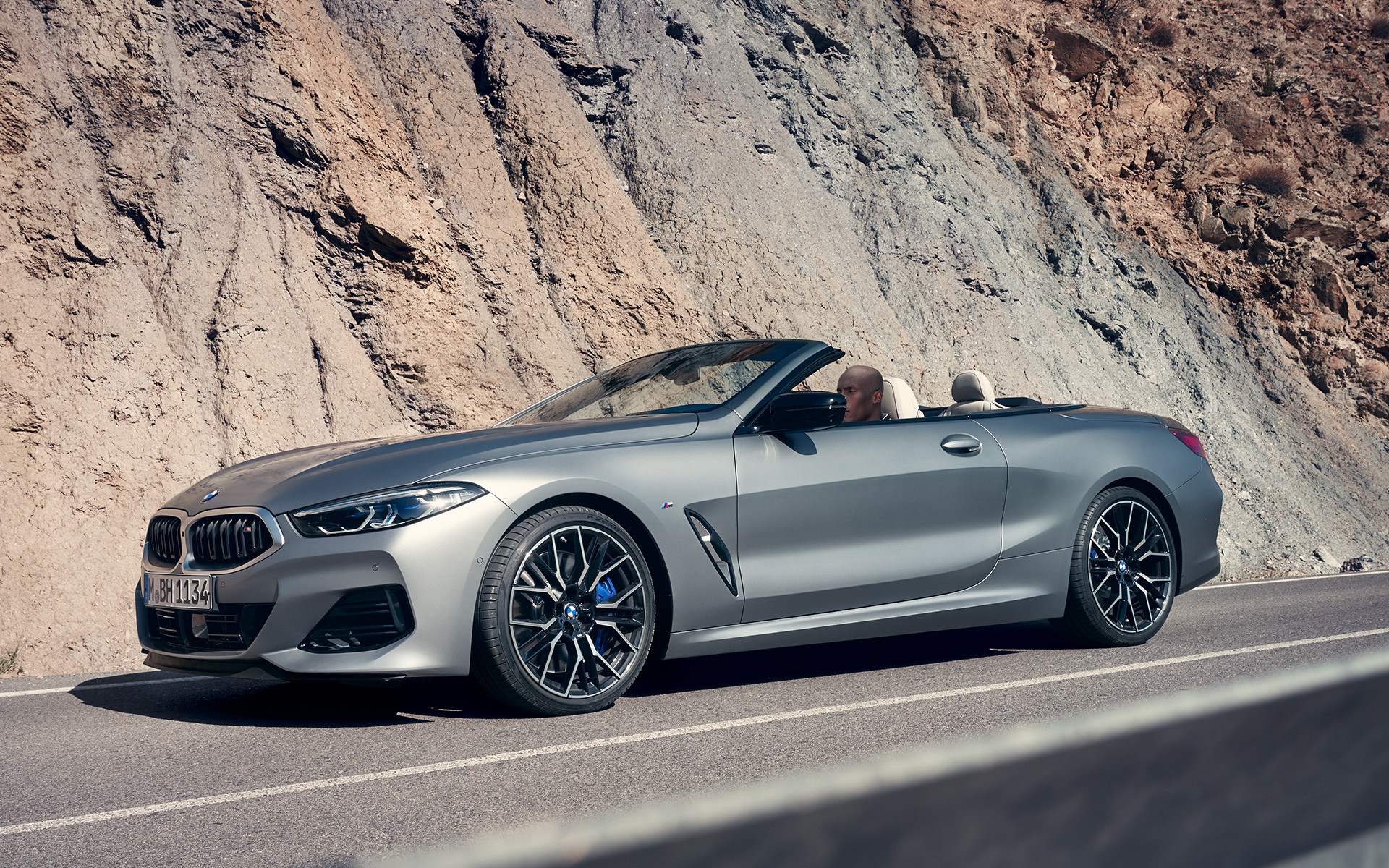 BMW M850i xDrive Cabrio G14 LCI Facelift 2022 BMW Individual Frozen Pure Grey metallic Dreiviertel-Frontansicht fahrend vor Felswand