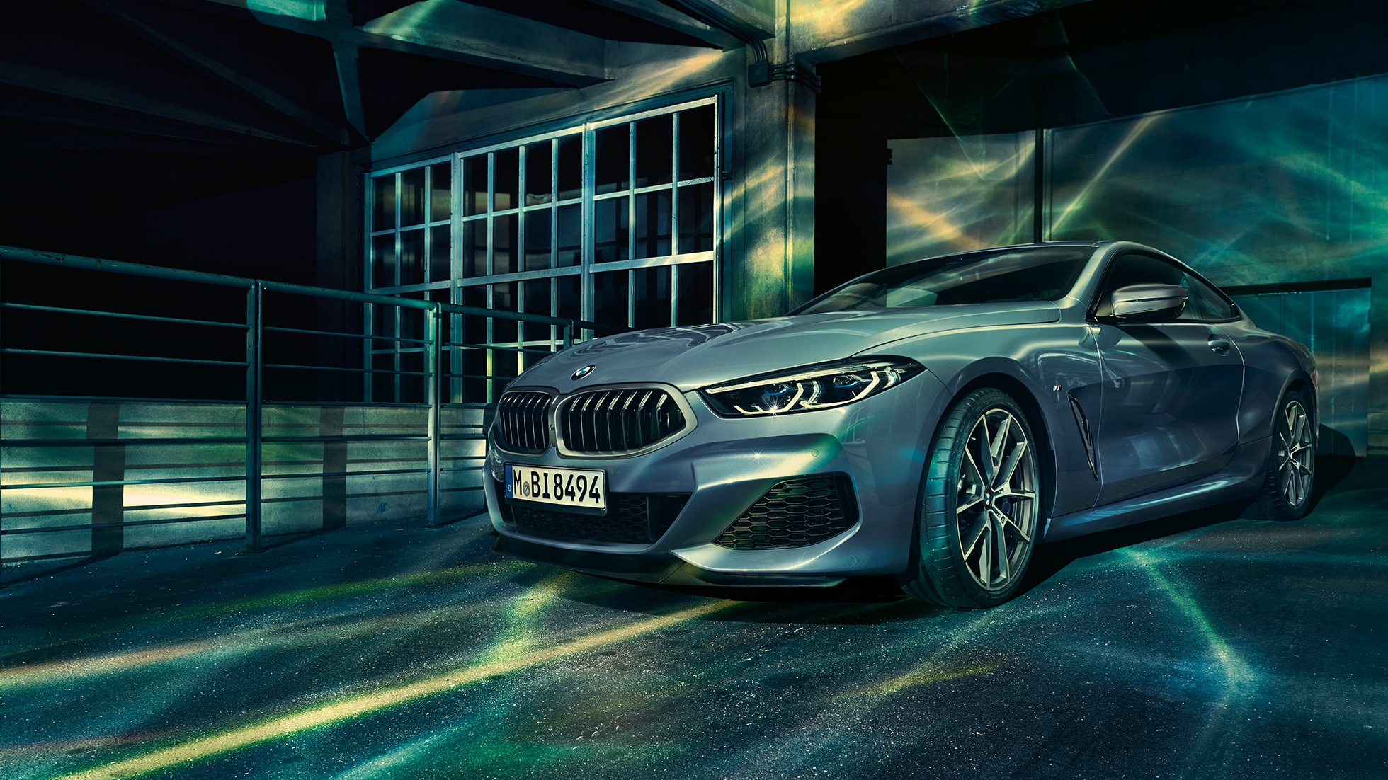 BMW M850i xDrive Coupé, Dreiviertel-Frontansicht. G15 BMW M850i xDrive Coupé in Barcelona Blau metallic, Dreiviertel-Frontansicht stehend vor Gebäude. G15