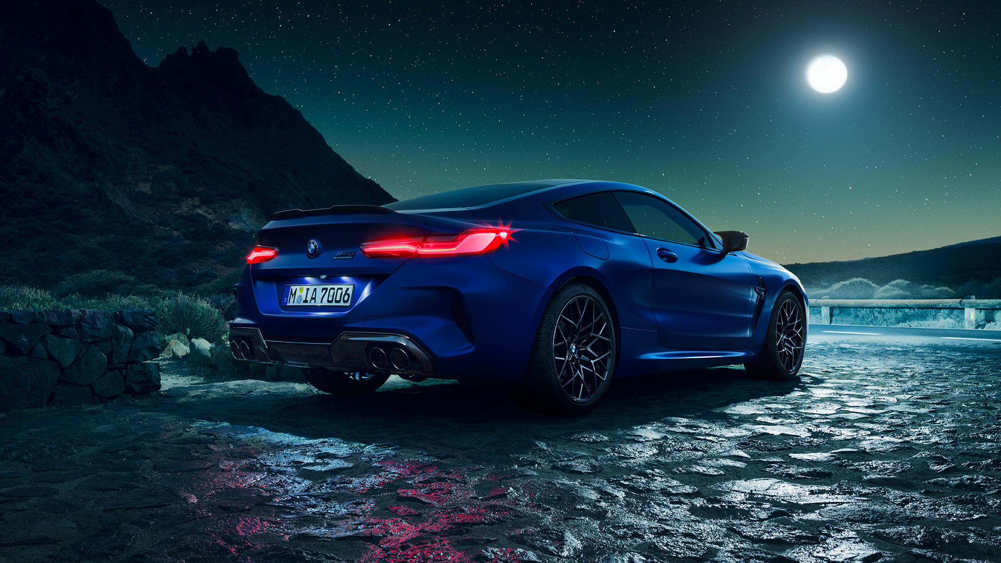 BMW M8 Competition Coupé, Dreiviertel-Heckansicht. F92 BMW M8 Competition Coupé in Marina Bay Blau metallic mit strahlenden LED-Heckleuchten, stehende Dreiviertel-Heckansicht bei Vollmond. F92
