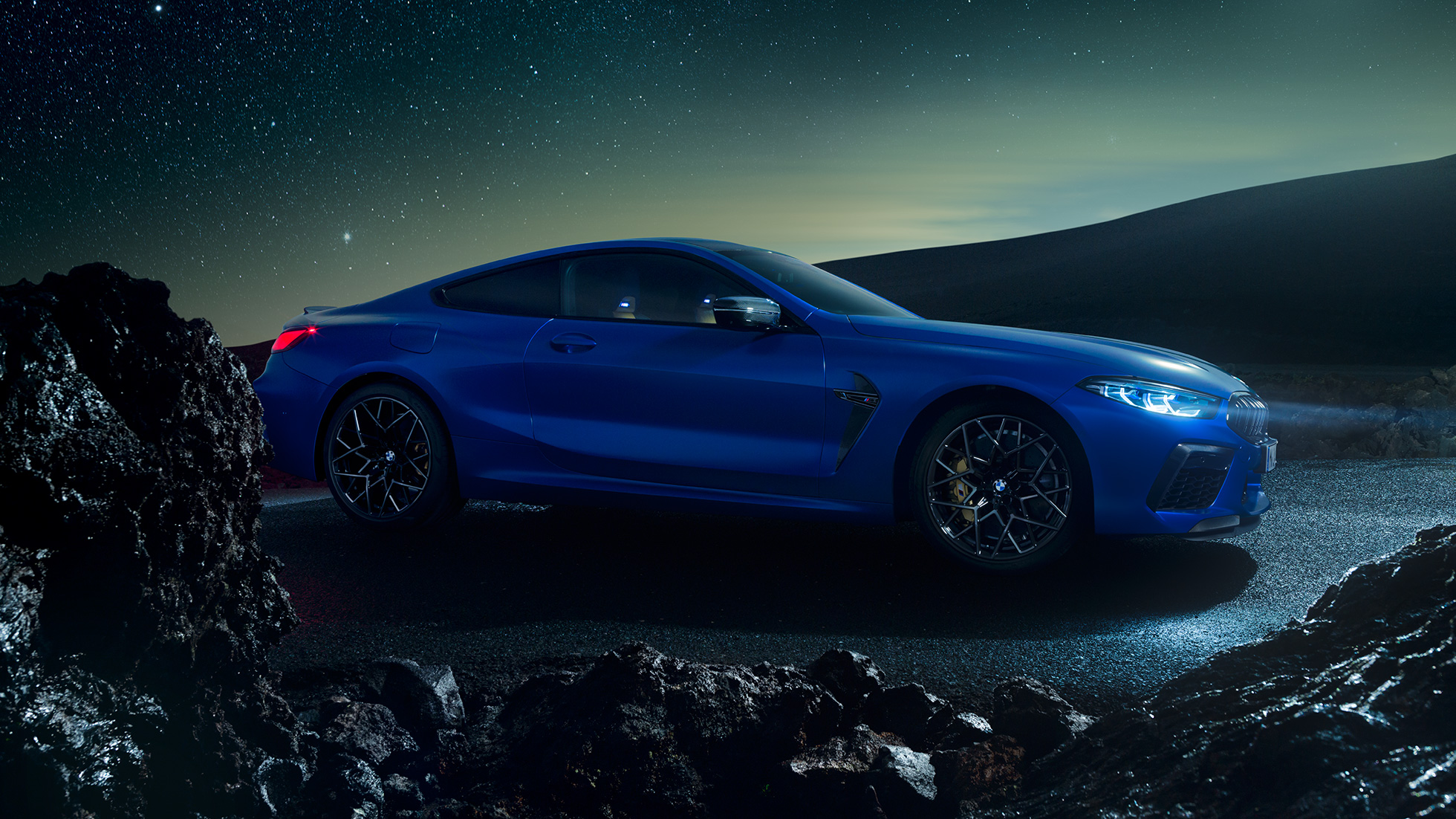 BMW M8 Competition Coupé, Dreiviertel-Seitenansicht. F92 BMW M8 Competition Coupé in Marina Bay Blau metallic, stehende Dreiviertel-Seitenansicht bei Nacht. F92