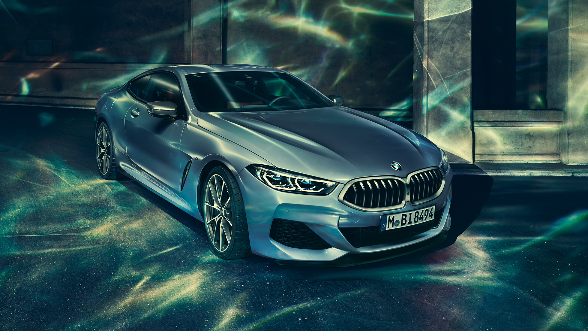 BMW M850i xDrive Coupé, Dreiviertel-Frontansicht links. G15 BMW M850i xDrive Coupé in Barcelona Blau metallic, Dreiviertel-Frontansicht links, stehend vor Gebäude. G15