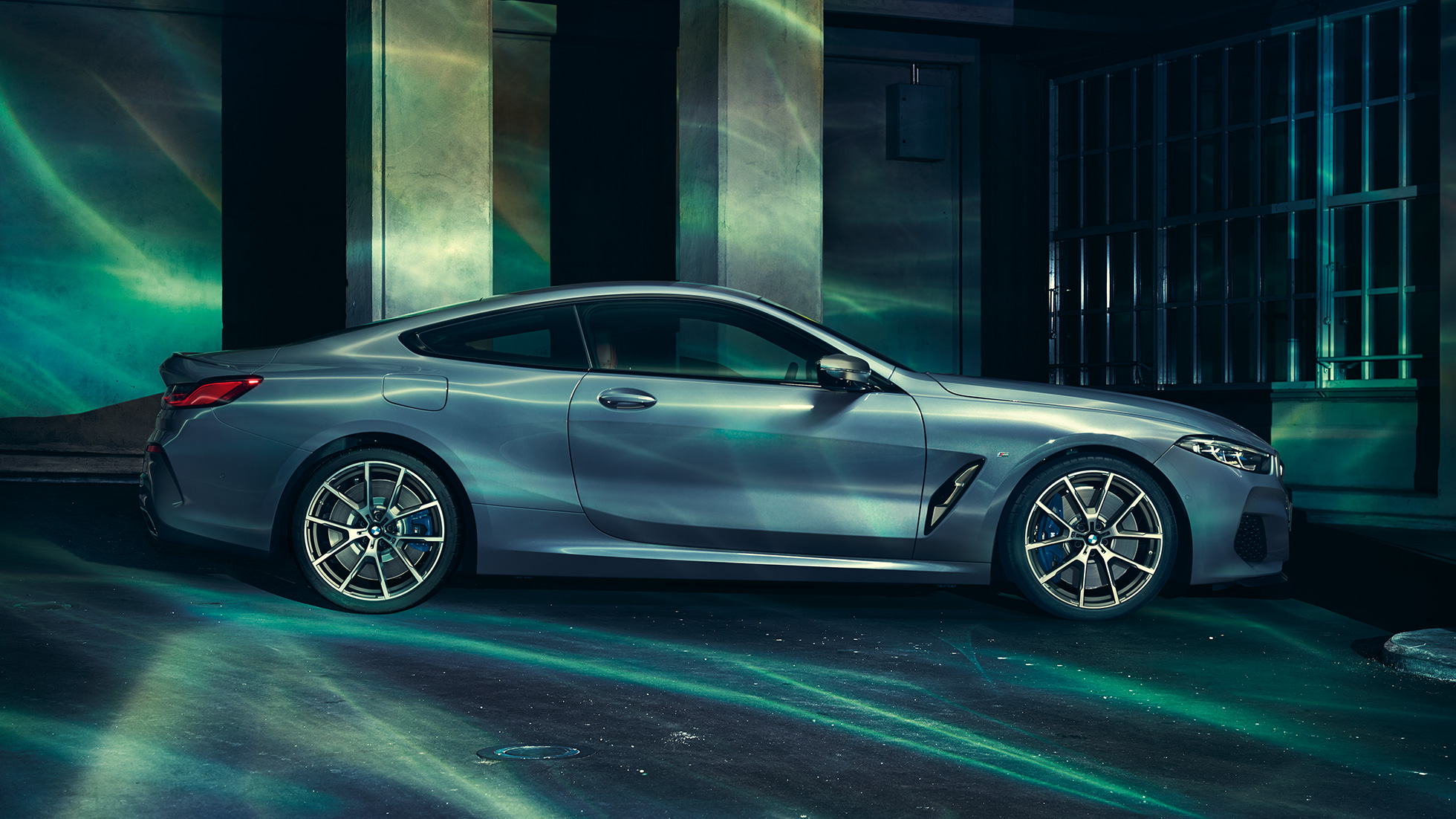 BMW M850i xDrive Coupé, Seitenansicht. G15 BMW M850i xDrive Coupé in Barcelona Blau metallic, Seitenansicht, stehend vor Gebäude. G15