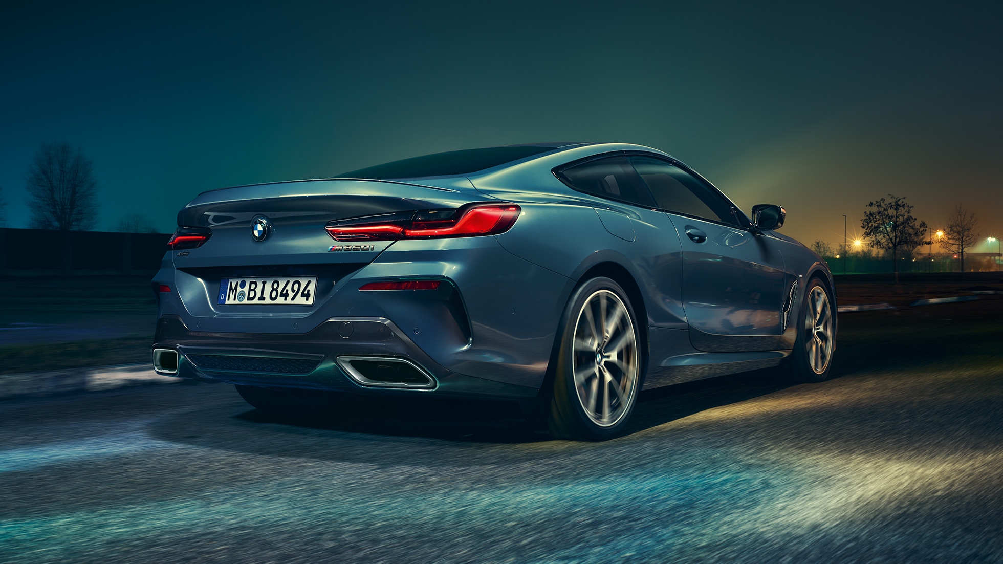 BMW M850i xDrive Coupé, Heckansicht. G15 BMW M850i xDrive Coupé in Barcelona Blau metallic, Heckansicht, fahrend bei Nacht. G15