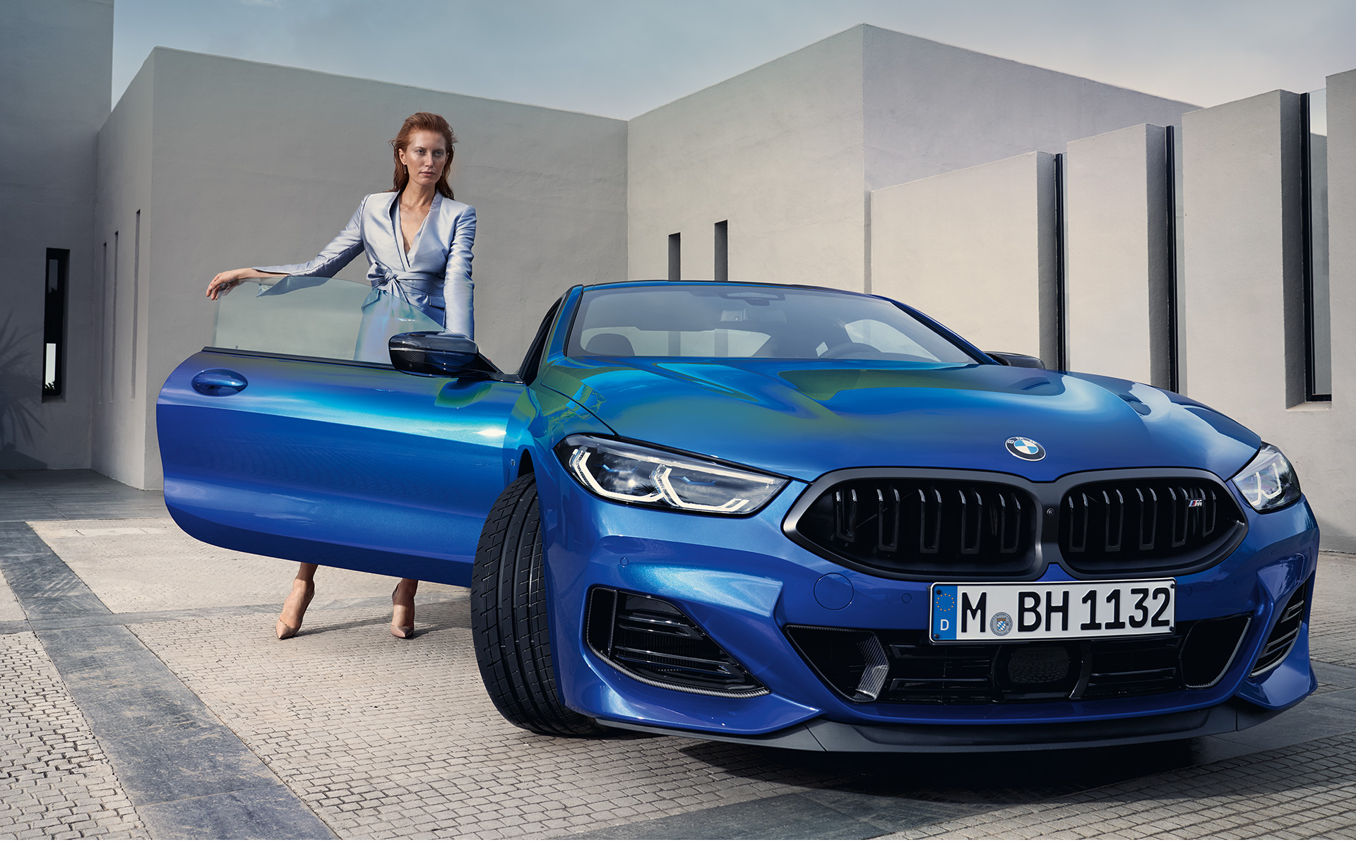 BMW M850i xDrive Coupé G15 LCI Facelift 2022 Frontansicht stehend BMW M850i xDrive Coupé G15 LCI Facelift 2022 M Portimao Blau metallic Frontansicht stehend mit weiblichem Model in geöffneter Beifahrertür
