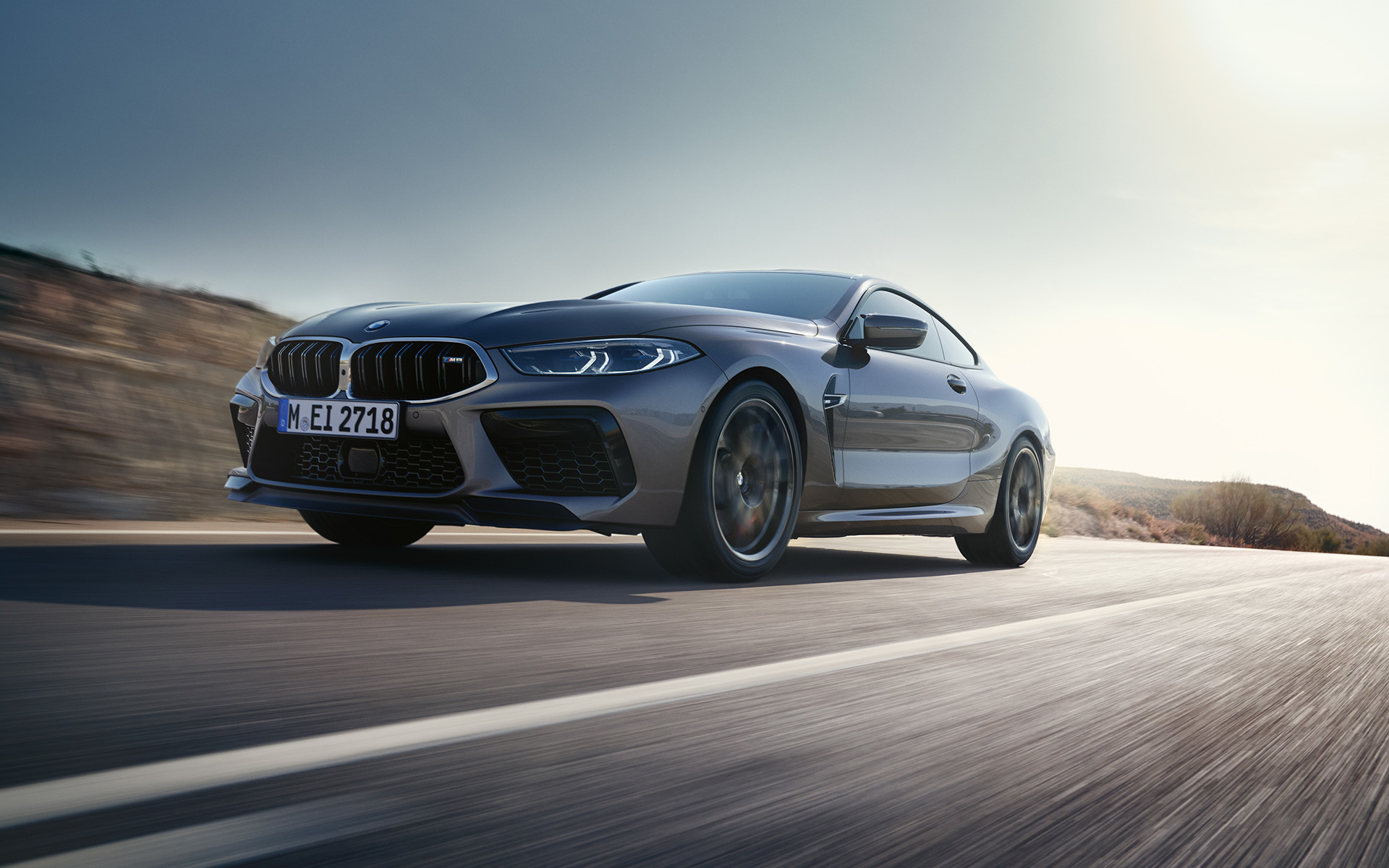 Dreiviertel-Frontansicht BMW M8 Coupé F92 LCI Facelift 2022 fahrend auf Landstraße BMW M8 Coupé F92 LCI Facelift 2022 Skyscraper Grau metallic Dreiviertel-Frontansicht fahrend auf Landstraße Froschperspektive