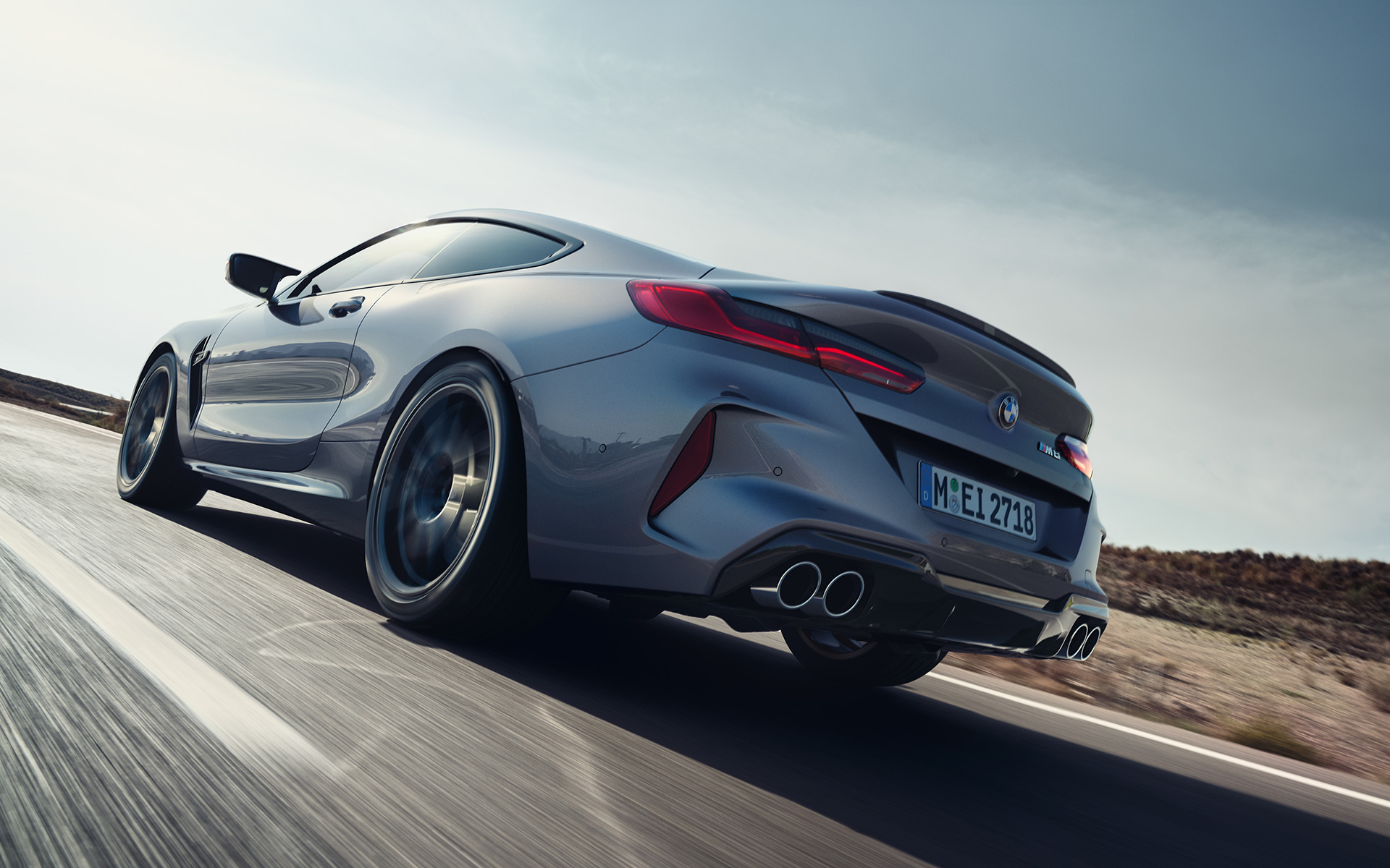 Dreiviertel-Heckansicht BMW M8 Coupé F92 LCI Facelift 2022 fahrend auf Landstraße BMW M8 Coupé F92 LCI Facelift 2022 Skyscraper Grau metallic Dreiviertel-Hecktansicht fahrend auf Landstraße Froschperspektive