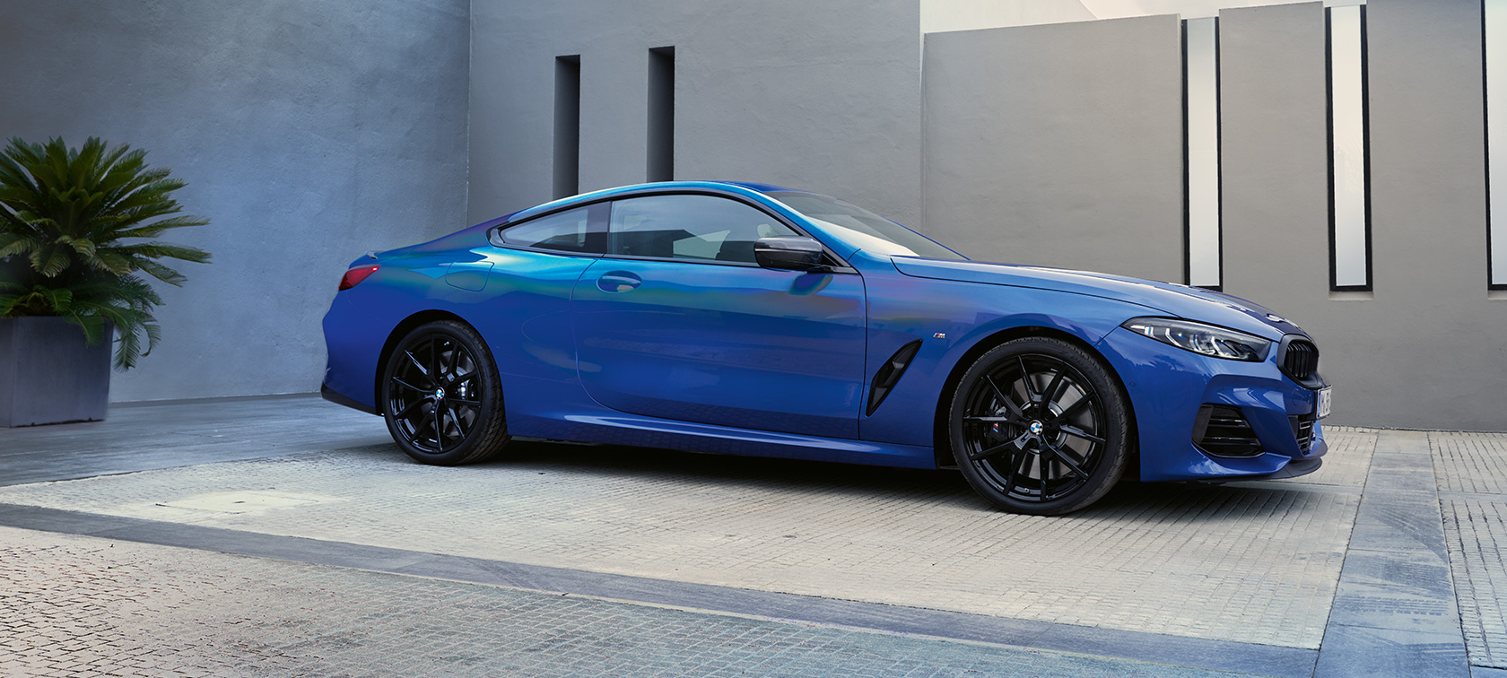 Seitenansicht BMW M850i xDrive Coupé G15 LCI Facelift 2022 BMW M850i xDrive Coupé G15 LCI Facelift 2022 M Portimao Blau metallic Seitenansicht stehend vor Gebäude