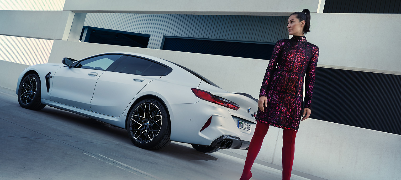 Vue de trois quarts arrière BMW M8 Competition Gran Coupé F93 LCI 2022 BMW M8 Competition Gran Coupé F93 LCI restylage 2022 BMW Individual Frozen Brilliant White metallic vue de trois quarts arrière avec modèle féminin à côté du véhicule