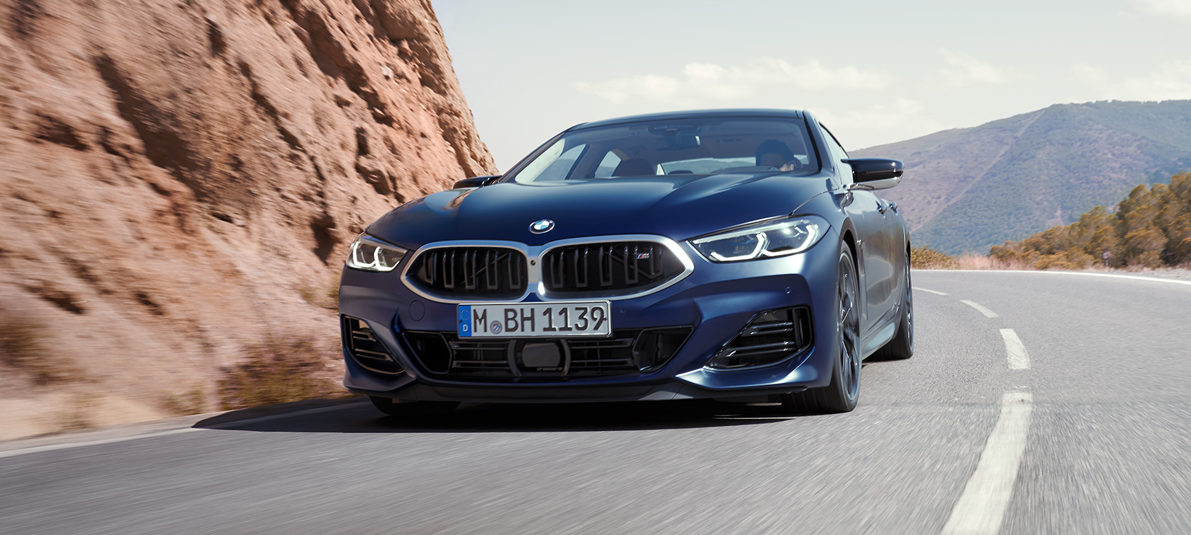 Vue de trois quarts avant en conduite BMW M850i xDrive Gran Coupé G16 LCI restylage 2022 BMW M850i xDrive Gran Coupé G16 LCI restylage 2022 BMW Individual Frozen Tansanitblau metallic vue de trois quarts avant en conduite dans un virage