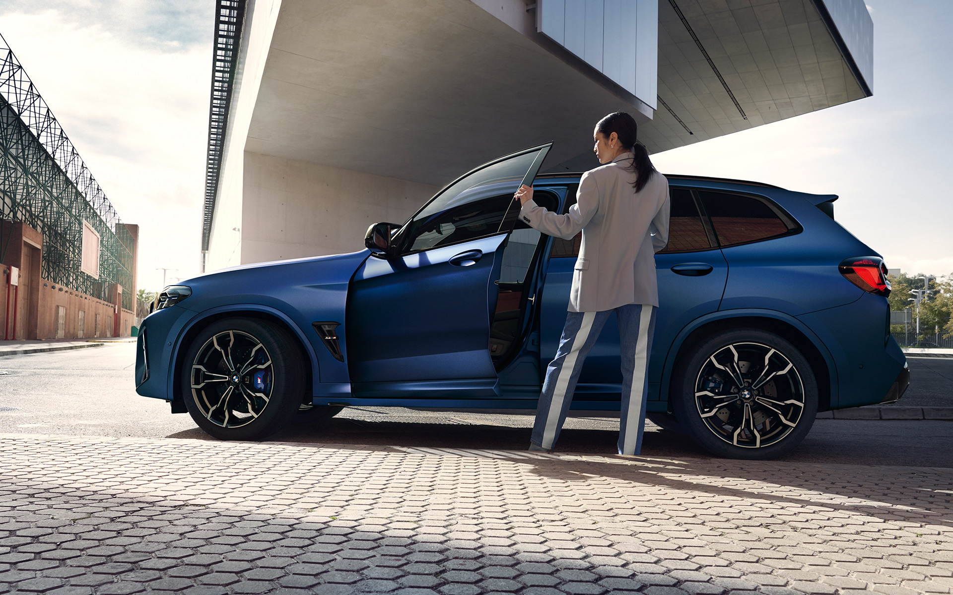 BMW X3 M Competition F97 LCI restylage 2021 Frozen Marina Bay Blau metallic Vue de profil avec portière ouverte et mannequin femme