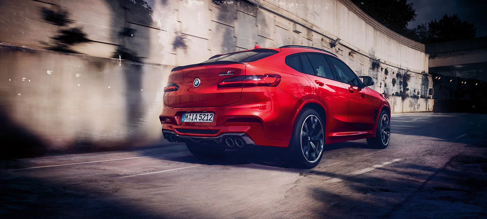 BMW X4 M Competition, Dreiviertel-Heckansicht. F98 BMW X4 M Competition in Toronto Rot metallic, fahrend, Exterieur, Dreiviertel-Heckansicht. F98