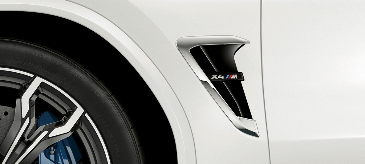 BMW X4 M, M Kieme. F98 BMW X4 M in Alpinweiß, Exterieur, M Kieme mit Chrom-Highlights und Modellkennzeichnung. F98