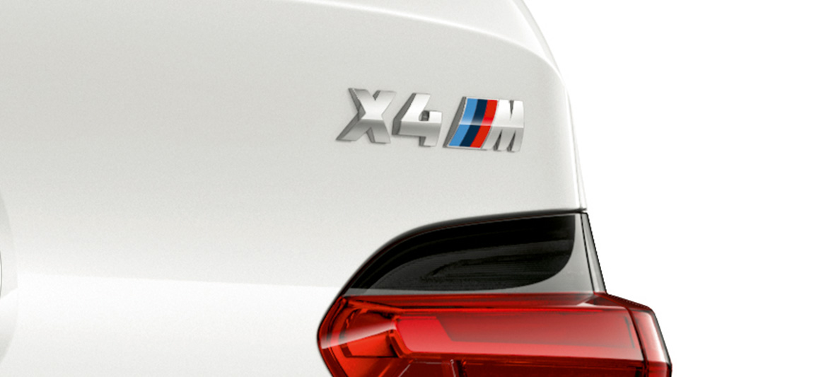 BMW X4 M, Modellkennzeichnung. F98 BMW X4 M in Alpinweiß, Exterieur, Nahaufnahme Heck mit Modellkennzeichnung. F98