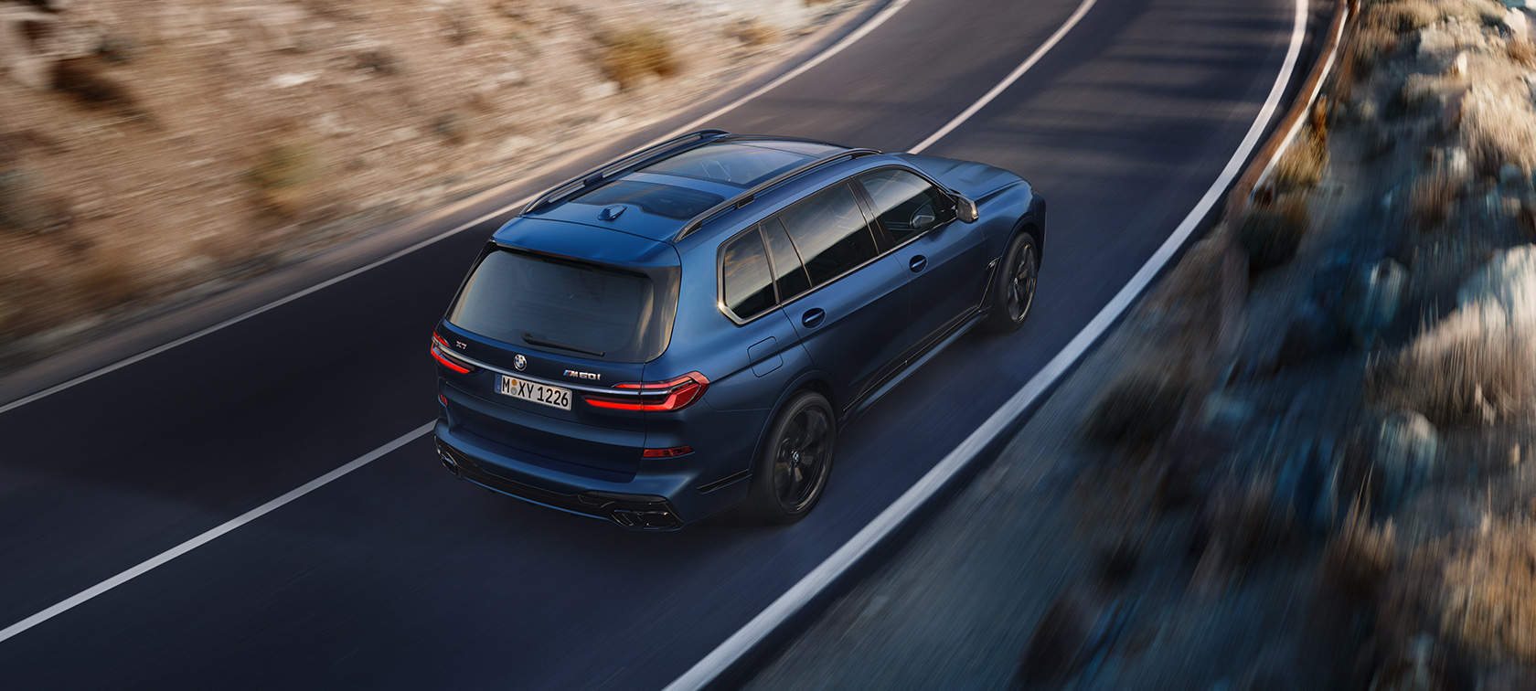 BMW X7 M60i xDrive G07 LCI Frozen Marina Bay Blue – vue du ciel de trois quarts arrière sur la route BMW X7 M60i xDrive G07 LCI Frozen Marina Bay Blue – vue du ciel de trois quarts arrière sur la route