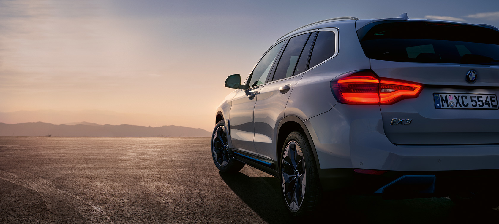 La BMW iX3 SUV électrique G08, à l'arrêt sur la route BMW iX3 SUV électrique G08 2020 en Mineralweiß metallic, vue de trois quarts arrière à l’arrêt, sur la route
