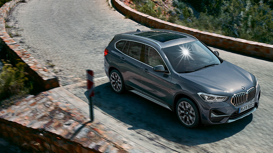 BMW X1 SUV, Dreiviertel-Frontansicht fahrend vor Gebirgskulisse. F48