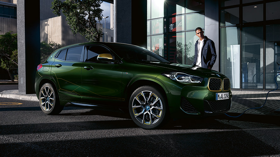 BMW X2 F39 Sanremo Green metallic Dreiviertel-Seitenansicht mit Model BMW X2 F39 Sanremo Green metallic Dreiviertel-Seitenansicht mit Model