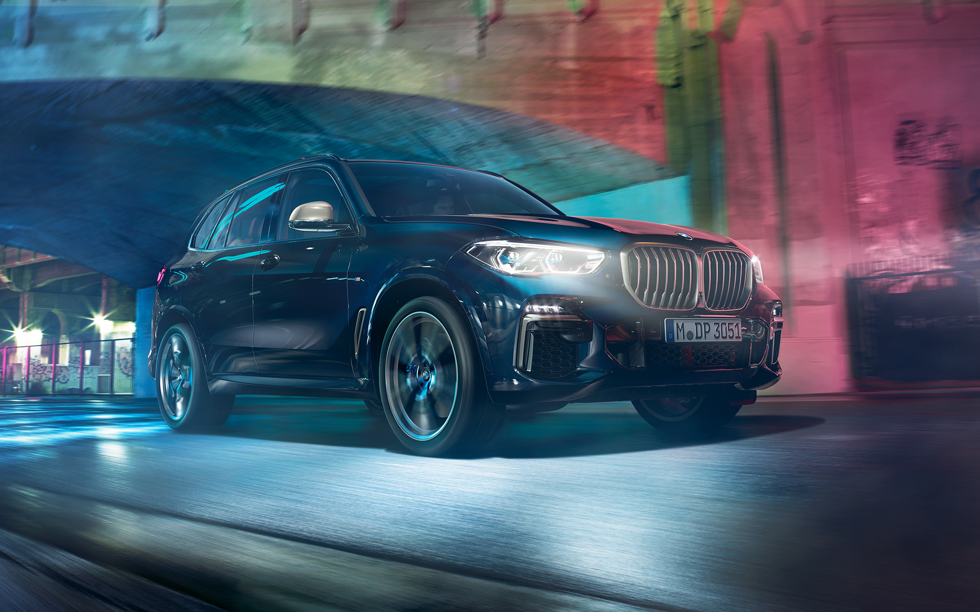 BMW X5 M50d in Aktion Fahraufnahme des BMW X5 M50d in der Nacht vor urbaner Kulisse