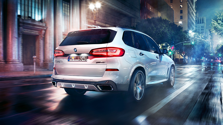 Heckansicht des BMW X5 M50d G05 vor nächtlicher urbaner Kulisse