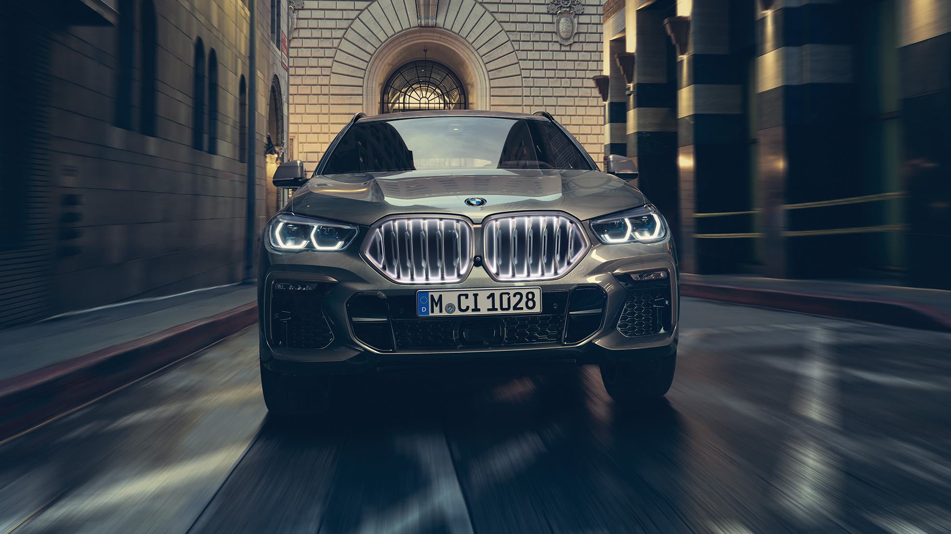 BMW X6 mit BMW Niere ‘Iconic Glow’. G06 BMW X6 in Frontansicht vor urbaner Kulisse. G06