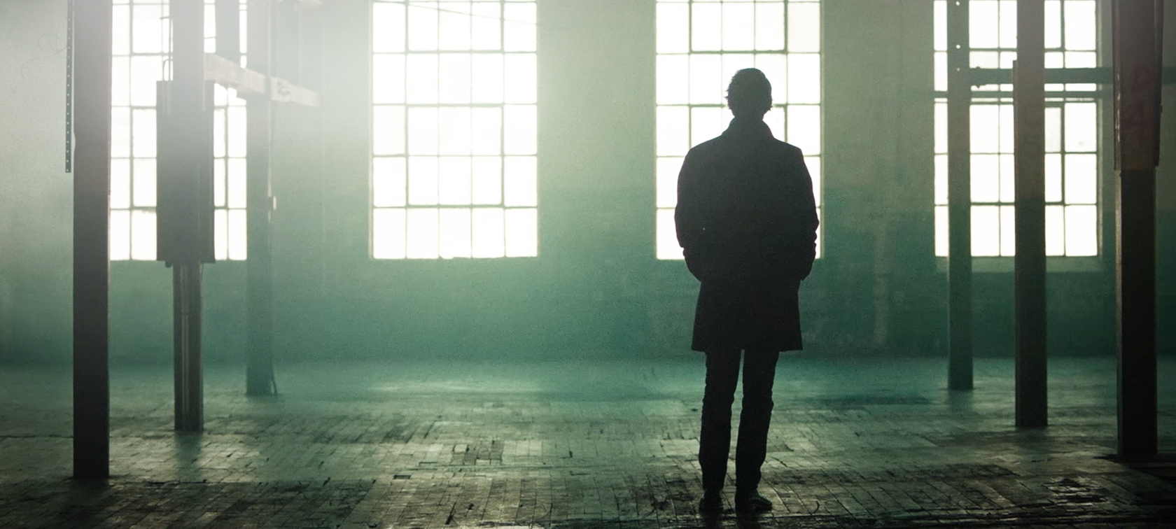Bold Voices Bold Voices : un homme est debout dans un hall d’usine vide à grandes fenêtres