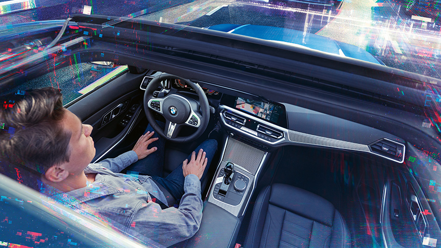 BMW Personal CoPilot : stationnement intelligent Un homme est assis dans une BMW stationnée et utilise l'assistant de stationnement de BMW Personal CoPilot