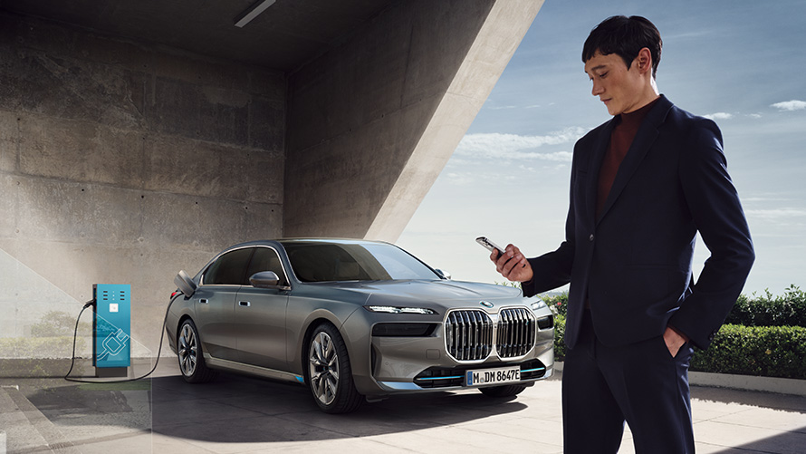 Connected Charging in der My BMW App Connected Charging in der My BMW App BMW i7 xDrive60 ladend mit Person im Vordergrund