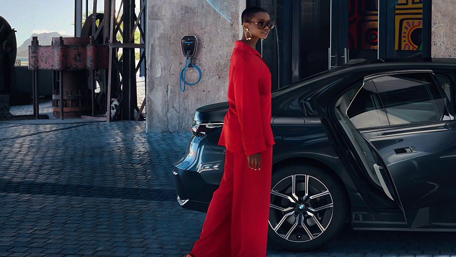 BMW Destination Charging BMW vor Hotel BMW Destination Charging Frau steht vor BMW Gebäude im Hintergrund