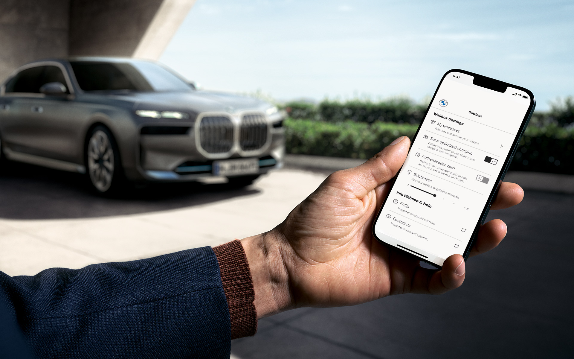 BMW i7 G70 Smartphone au premier plan affichant l’application My BMW