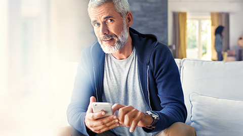 BMW Shop Homme avec smartphone sur le canapé