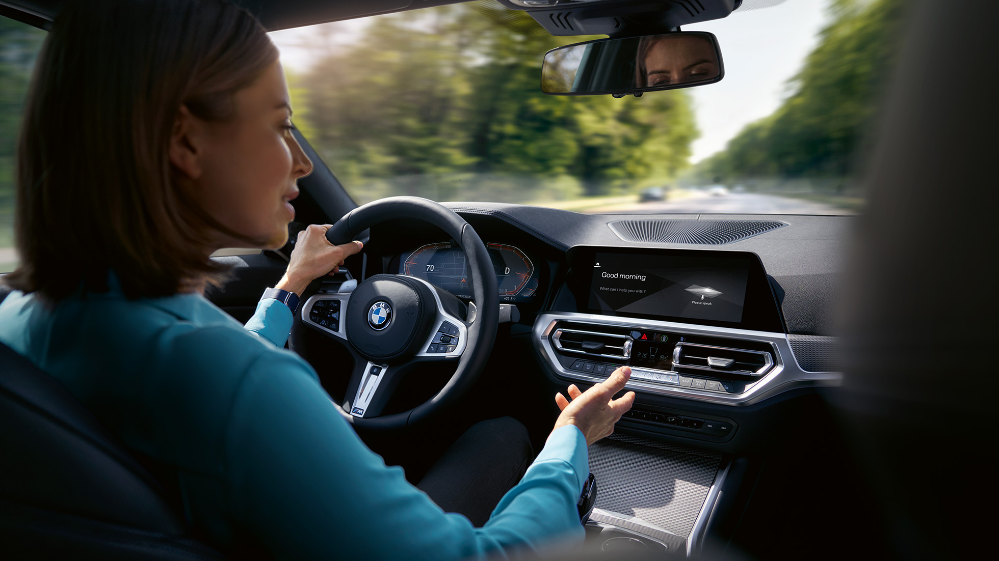 Une femme utilise l'Intelligent Personal Assistant dans sa BMW. Une femme utilise l'Intelligent Personal Assistant de BMW ConnectedDrive dans sa BMW.