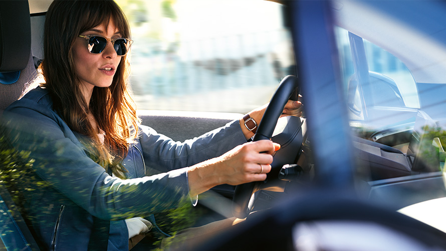 Frau gibt Amazon Alexa Anweisungen am Steuer ihres BMW