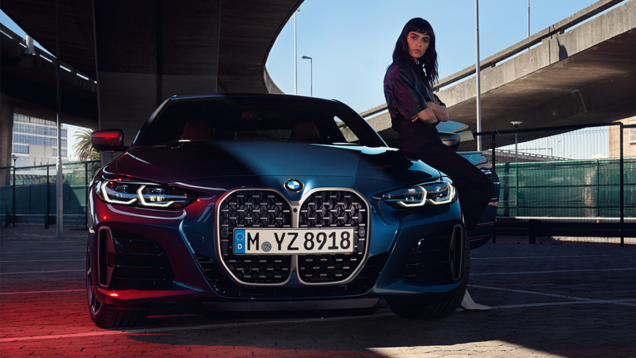 Femme adossée à une BMW Série 4 Coupé Remote Software Upgrade Femme adossée à une BMW Série 4 Coupé