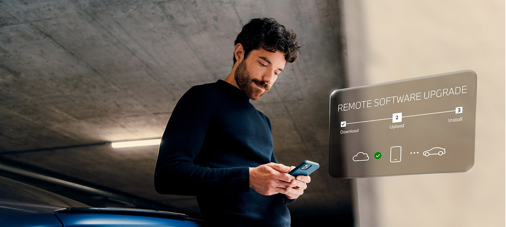 Homme devant BMW regardant son smartphone Remote Software Upgrade Homme devant BMW regardant son smartphone