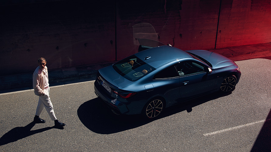Remote Software Upgrade homme derrière l’arrière d’une BMW traversant la rue Homme derrière l’arrière d’une BMW traversant la rue