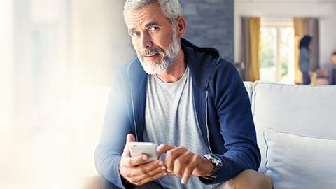 BMW ConnectedDrive Store Homme avec smartphone sur le canapé