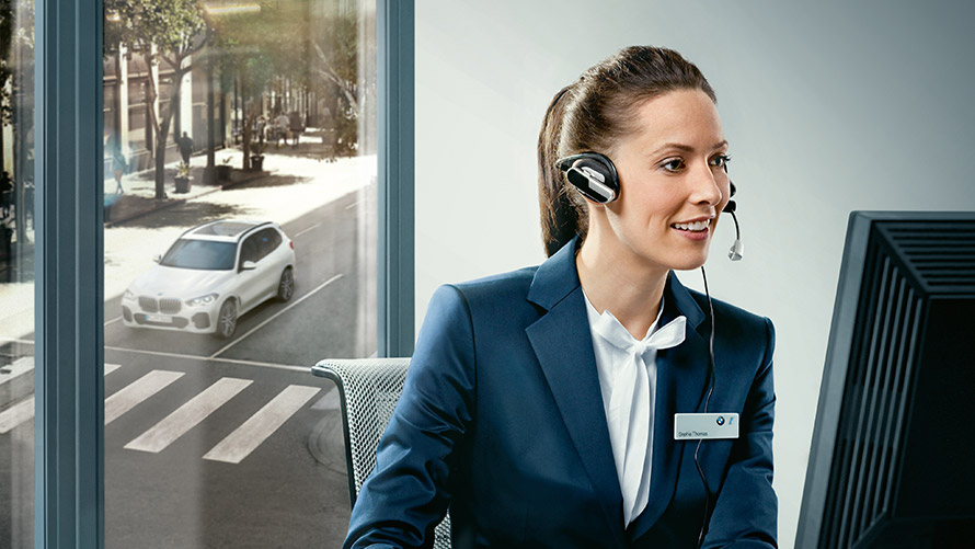 Concierge Services: BMW Mitarbeiterin sitzt mit Headset vor Bildschirm Concierge Services: BMW Mitarbeiterin sitzt mit Headset vor Bildschirm