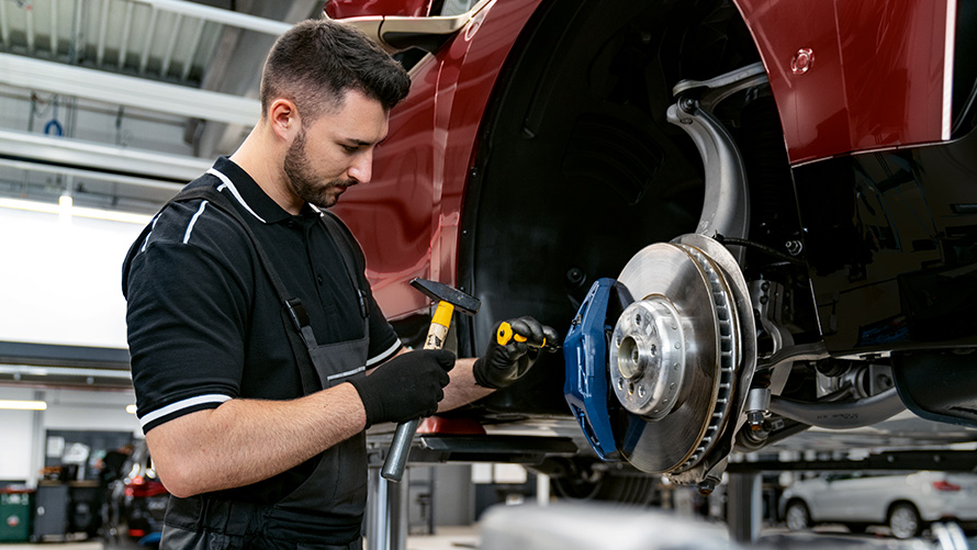 BMW Service Inclusive Plus Leistungen BMW Service Inclusive Plus Werkstattmitarbeiter arbeitet an Bremsen