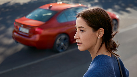 La conductrice d’une BMW attend la gestion des pannes et des accidents BMW devant sa voiture