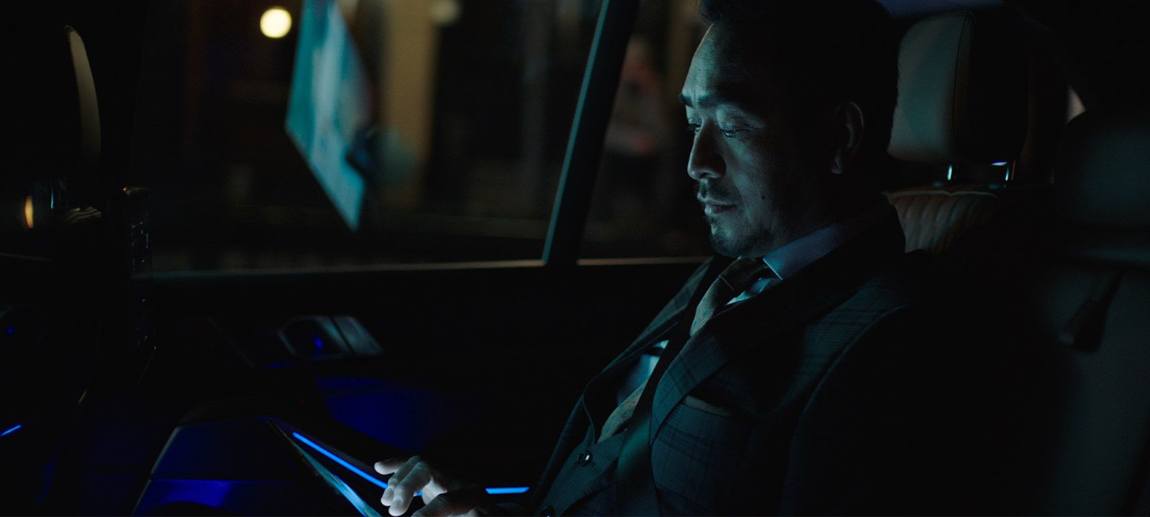 BMW Legal Information Man riding in back of BMW at night