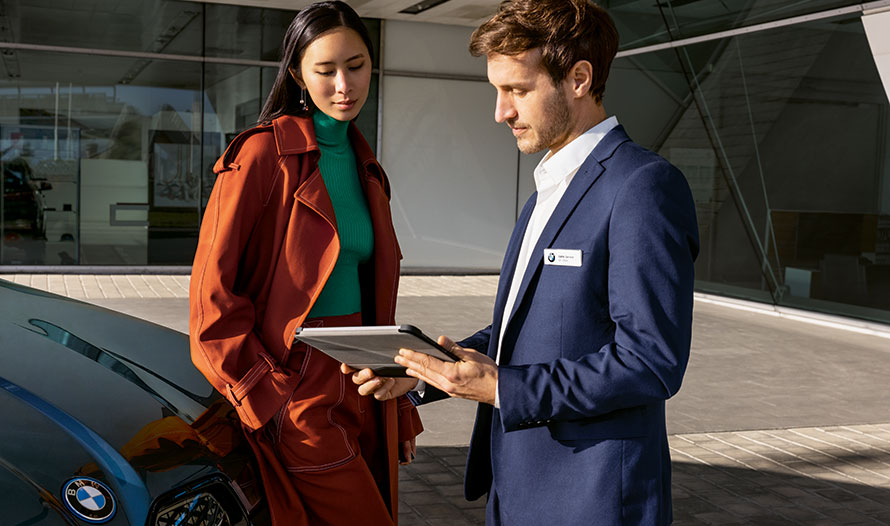 BMW Corporate Sales Dienstleistungen Finanzierung und Leasing für Firmenkunden Männer gehen zu BMW Fahrzeug