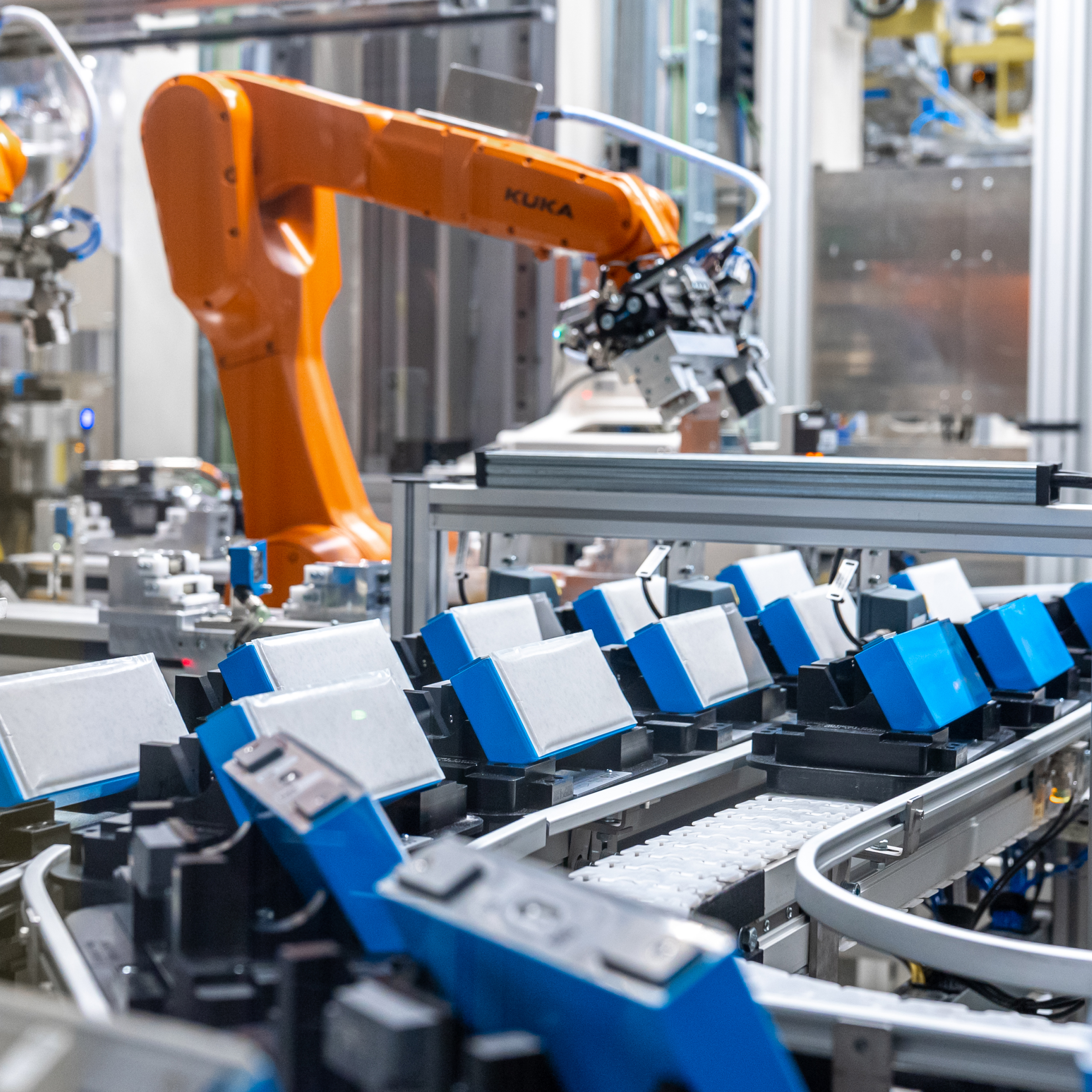 Gros plan sur plusieurs batteries bleu et blanc sur la ligne de production dans l’usine BMW